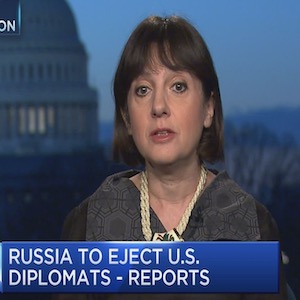 image of Olya Oliker in a grey suit talking on a CNBC interview
