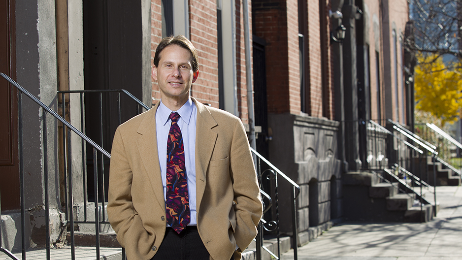 Mark Salzer standing in front of rowhomes.