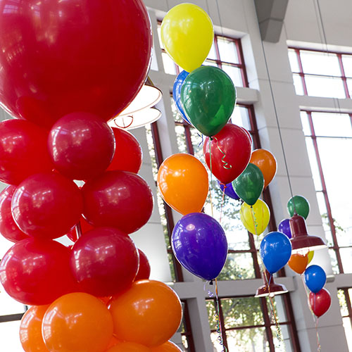 Rainbow balloons hanging in the student center atrium.