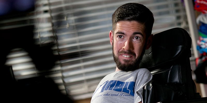 A man in a wheelchair wearing his [dis]ABLE brand T-shirt.