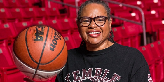 Professor Karen Turner poses with a basketball in the Liacouras Center.