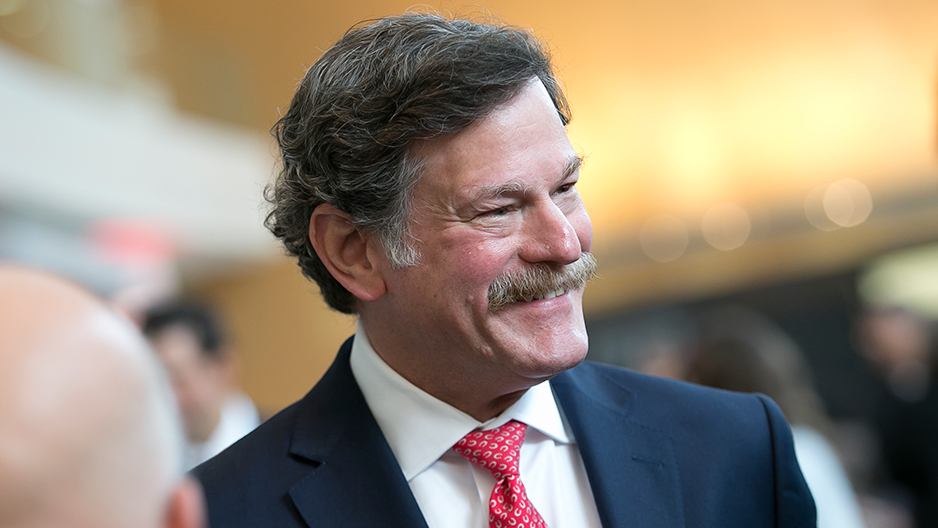 Larry Kaiser smiling as he mingles with guests at medical school event.