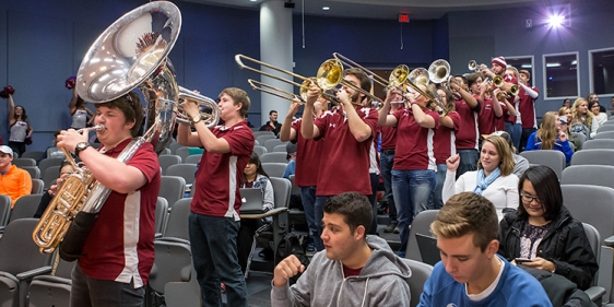 The Temple marching band playing in a lecture hall during pop-up pride celebration.