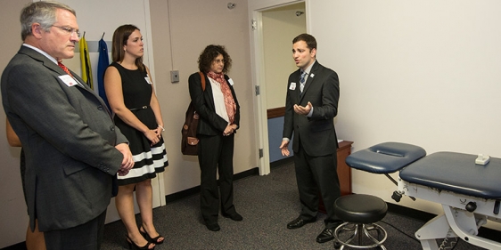 Temple President Neil D. Theobald tours the clinic with physical therapy students and CPH Dean Laura Siminoff