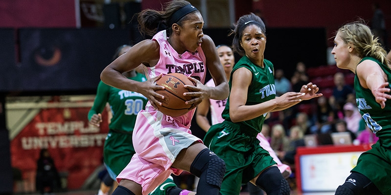 A Temple women s basketball player holding the ball while making a play.
