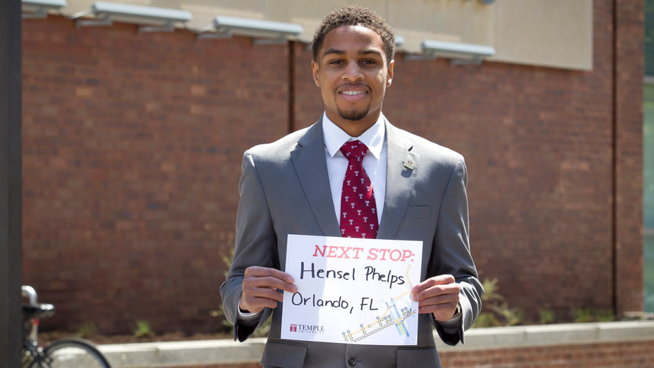 A man wearing a Temple T tie, standing in front of the engineering building.