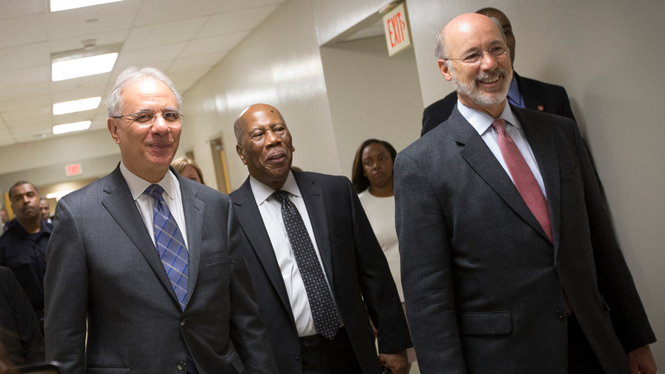 Three men in suits touring the new medical suite at Temple s dental school.
