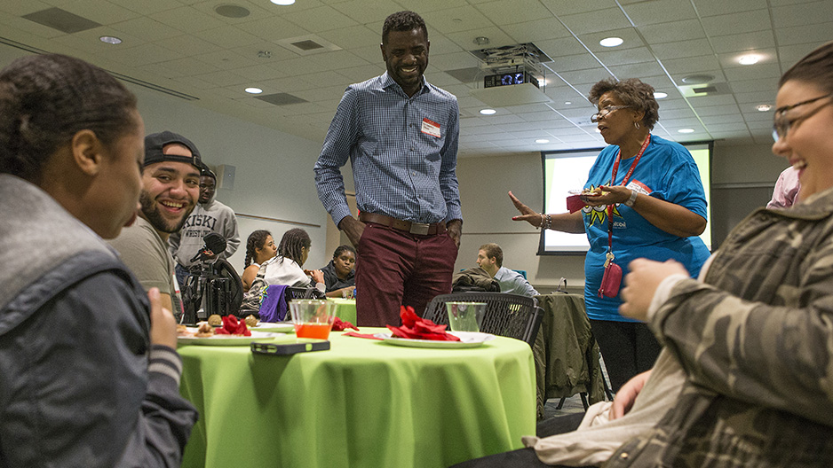 A group of students cheering at a Temple athletic event.