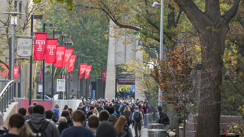A crowd of students walking on Polett Walk towards the Bell Tower.