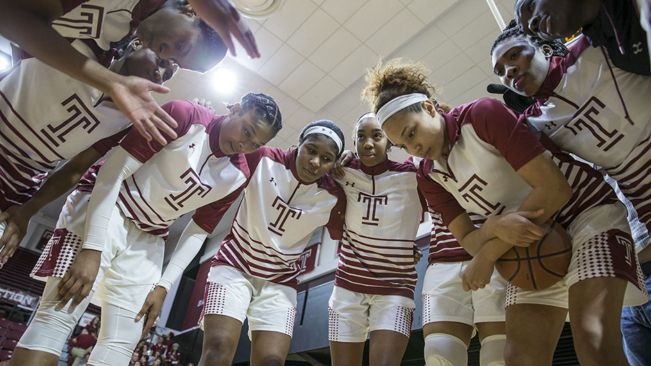 The women s basketball team having a team huddle.