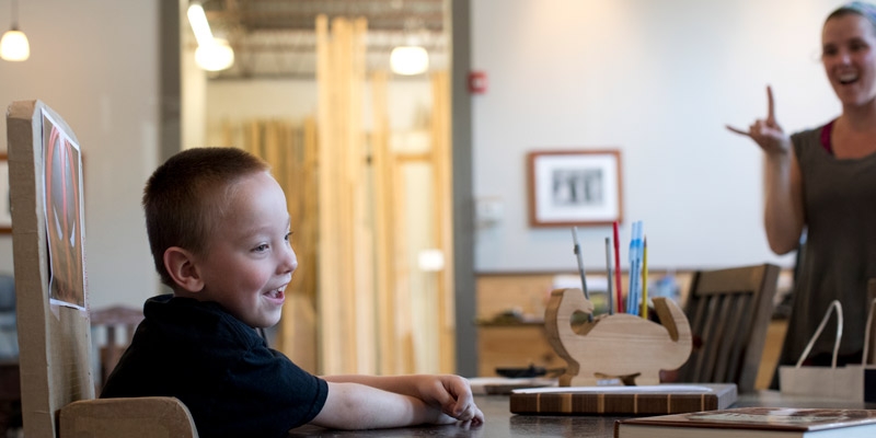 Mark Ovington, 5, sitting in his adaptive chair made of cardboard