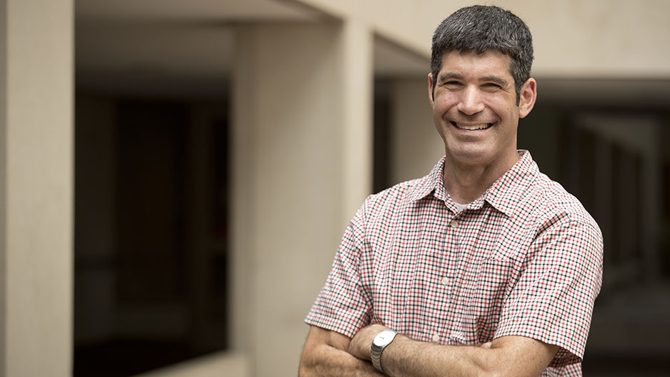 Daniel Berman standing with his arms crossed, smiling.