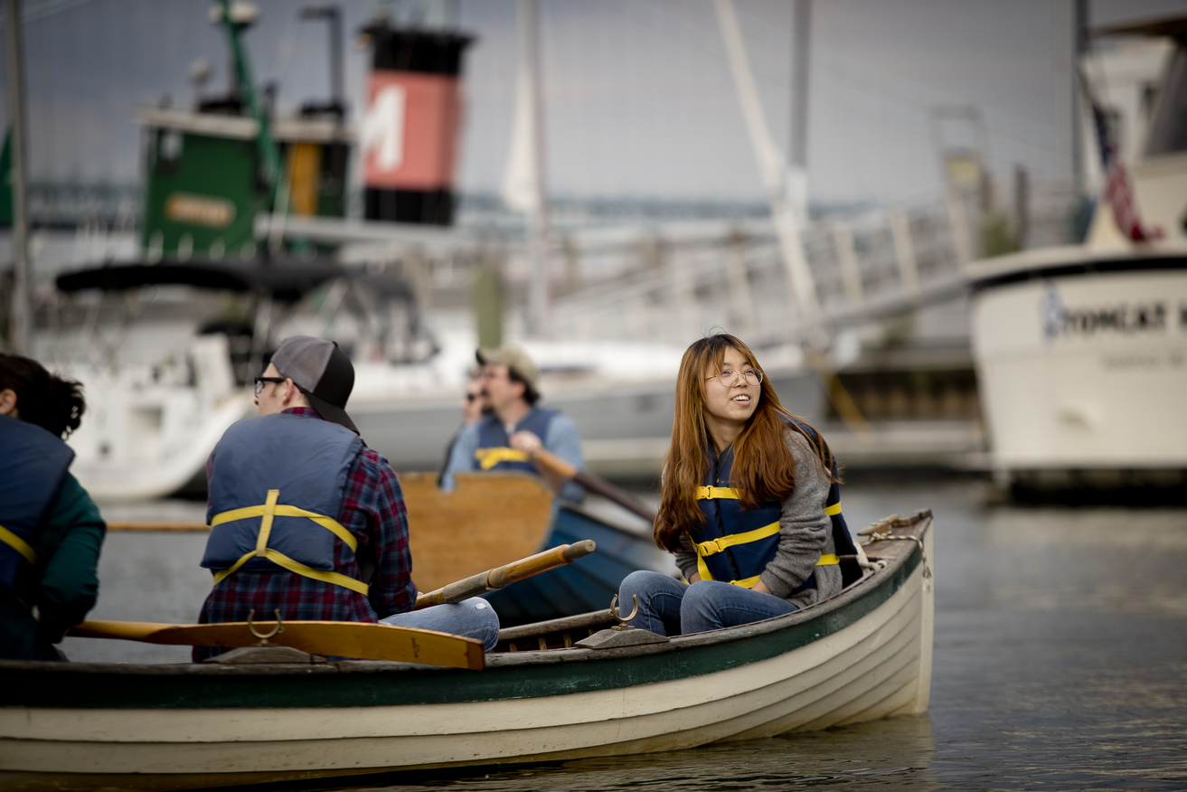 students and professor on a row boat
