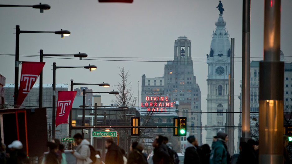 People crossing Broad Street on Temple s campus with City Hall in the background
