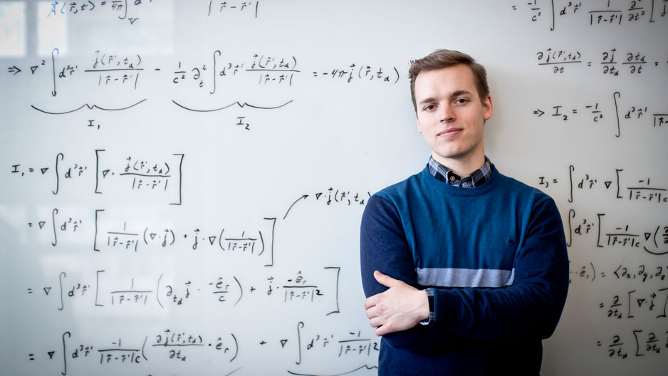 Marcus Forst in front of a whiteboard filled with equations