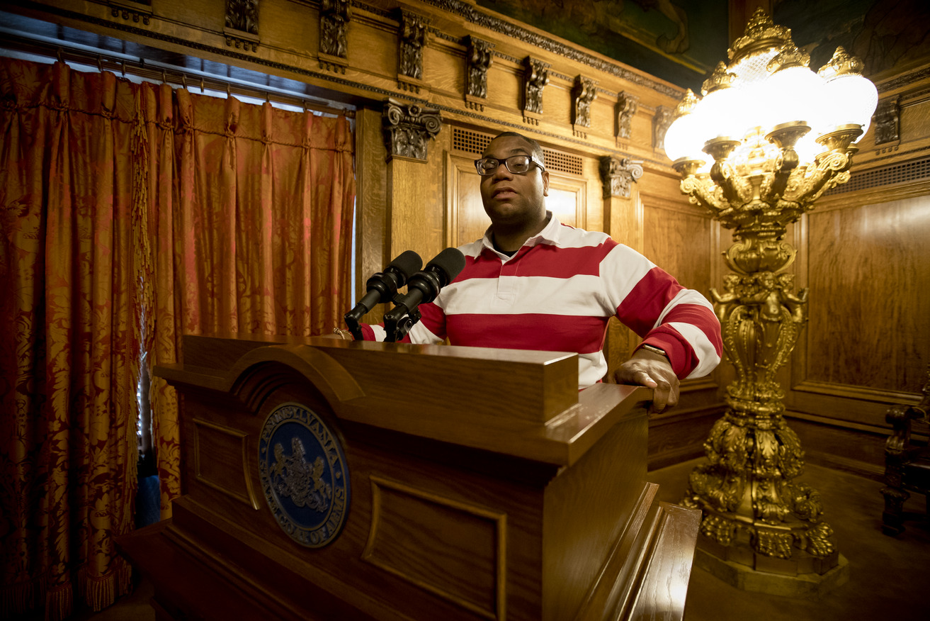 Image of Shawn Aleong behind a podium at the Pennsylvania State Capitol.