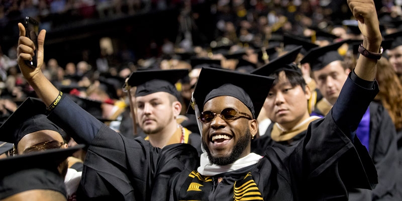 A graduate celebrating at Temple s Commencement