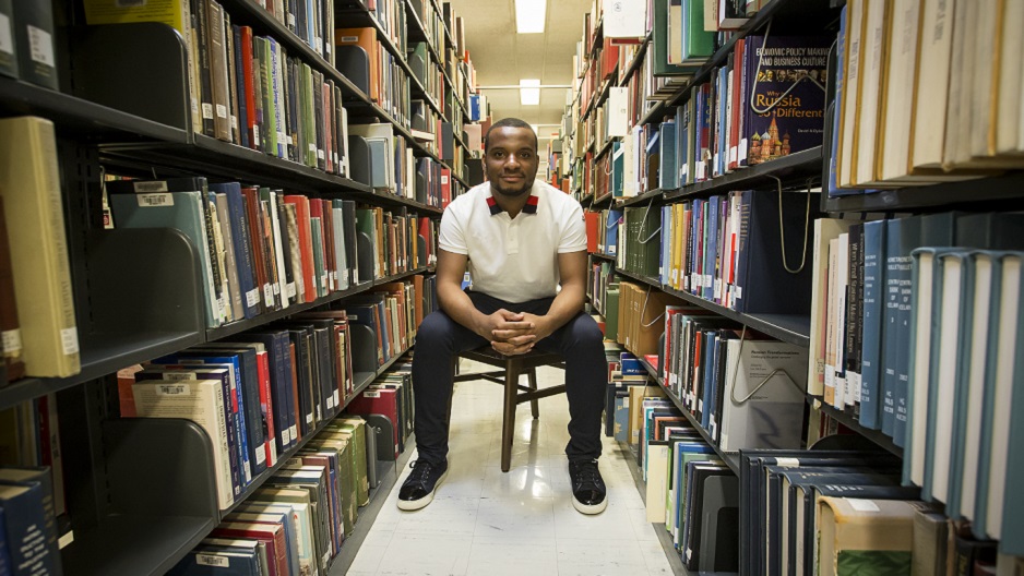 Hazim Hardeman sitting among the stacks at Paley Library.