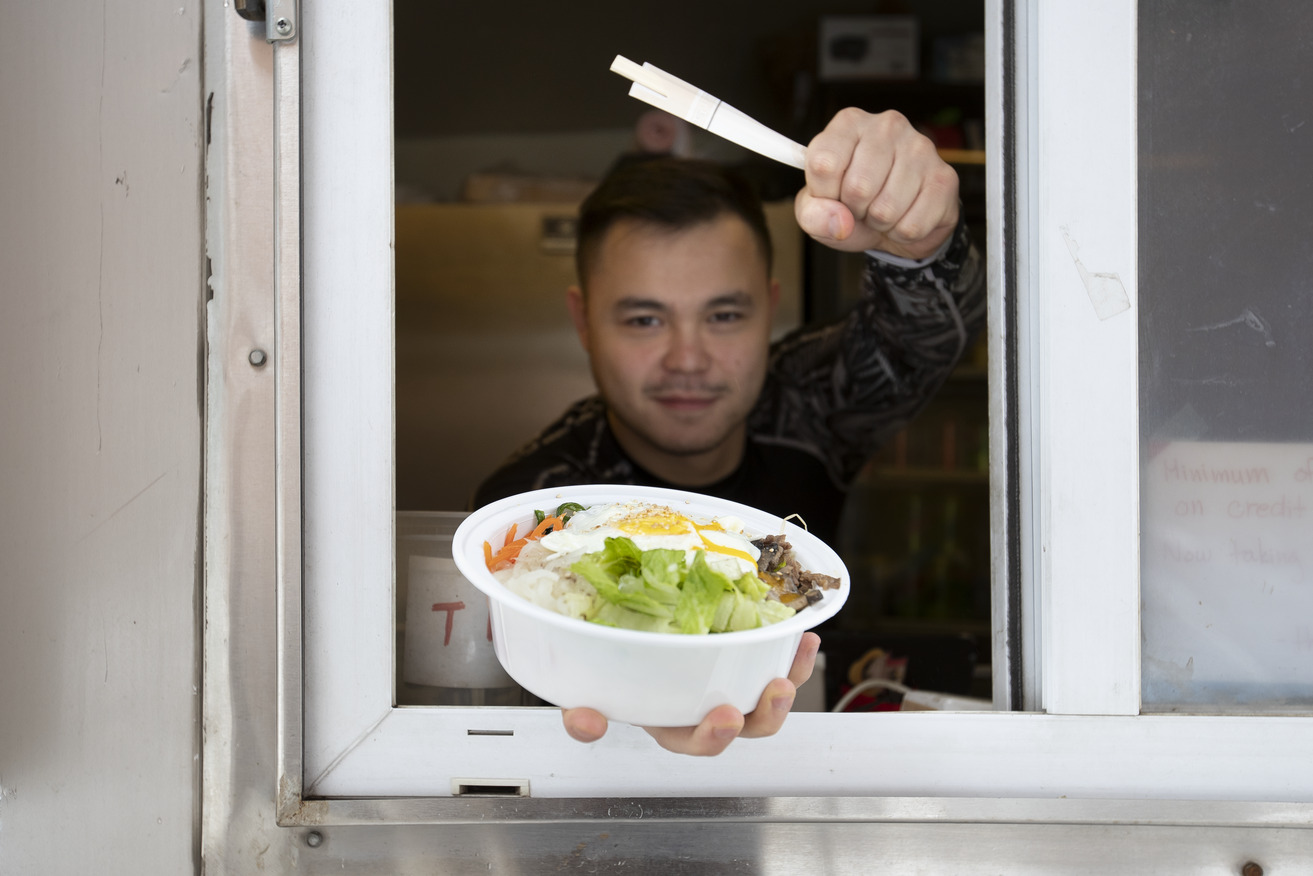 A food truck vendor shows off a meal