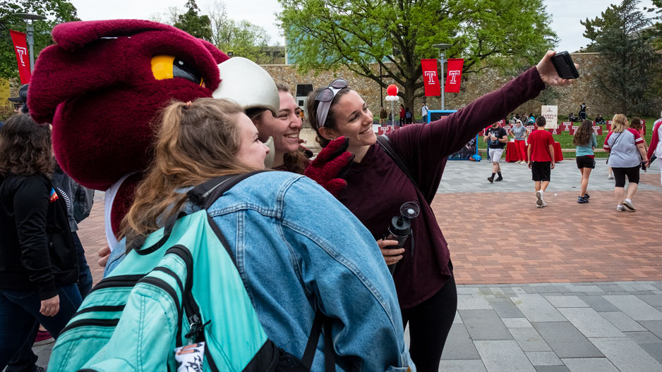 Students taking a selfie with Temple mascot Hooter