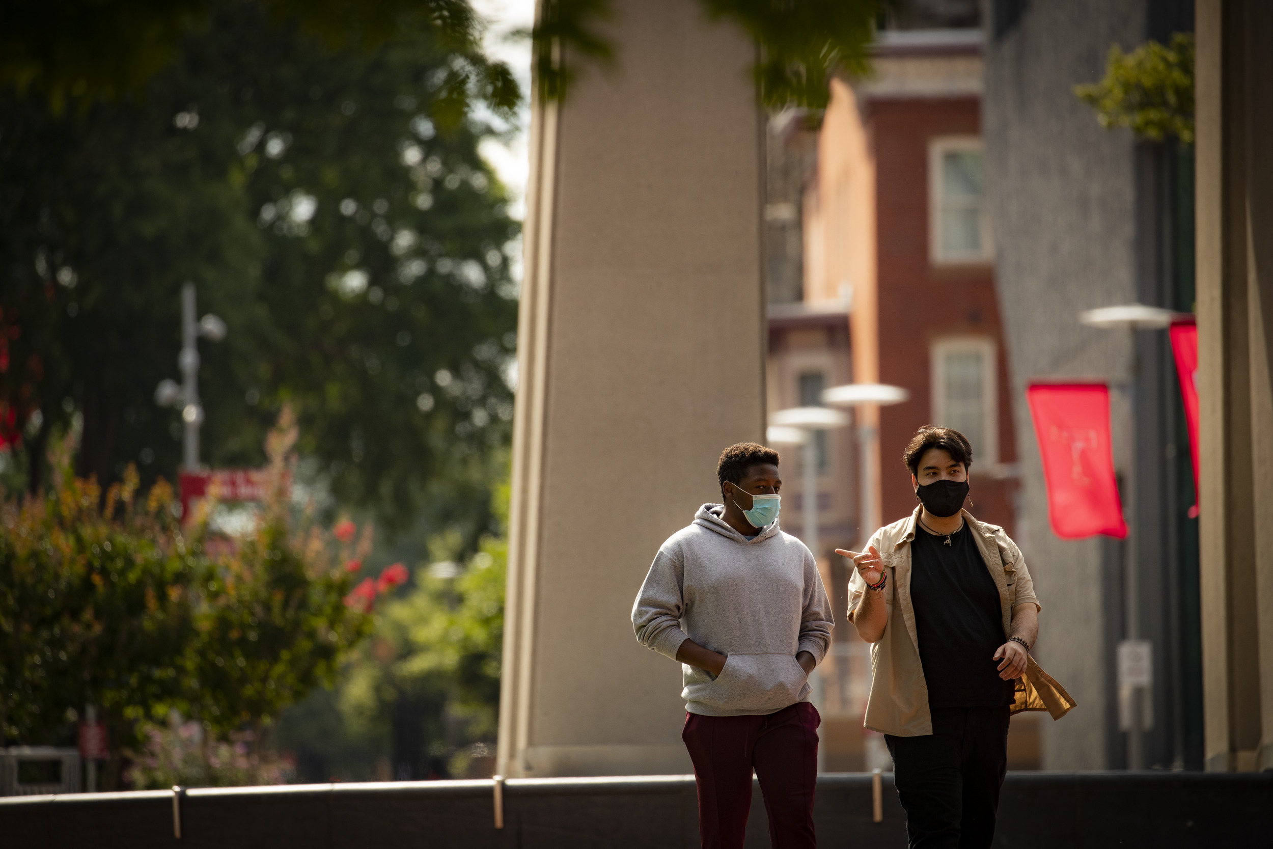 Image of two students wearing face coverings walking down Polett Walk on Main Campus.