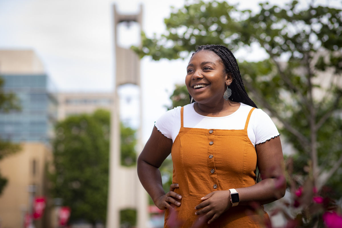 student in front of the bell tower