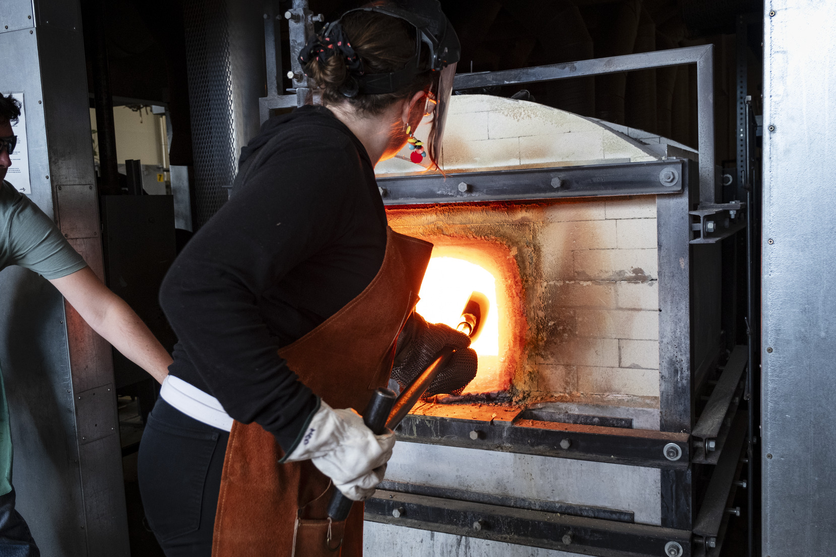Temple faculty demonstrating glassblowing furnace