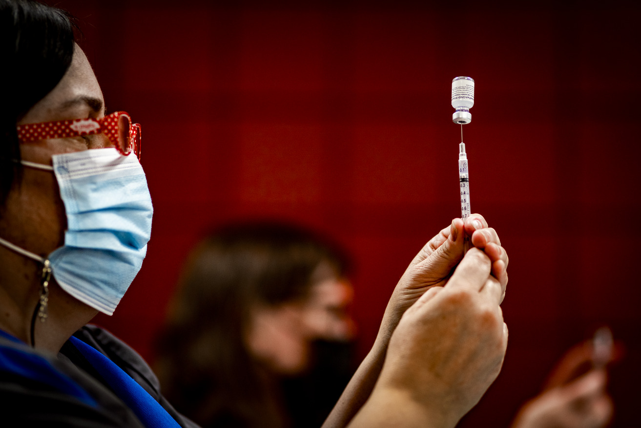 An staff member from Student and Employee Health Services gets ready to administer the COVID-19 vaccine.