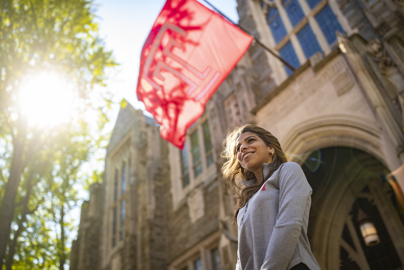 Jennifer Sierra standing under a Temple flag.