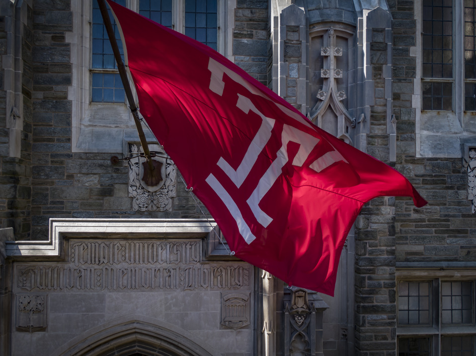 Image of the cherry and white Temple T flag outside of Sullivan Hall on Main Campus.