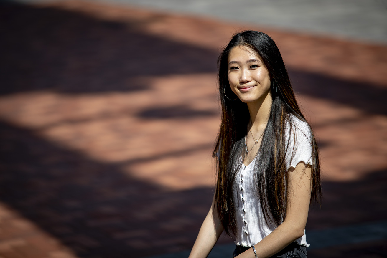 Michelle Wu wearing a white shirt and smiling outside of a building.