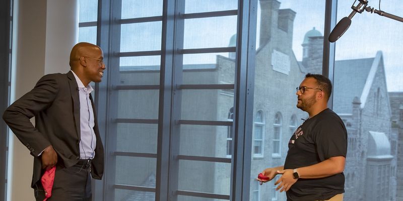 President Jason Wingard and Niccolas Uff talking under a boom microphone.