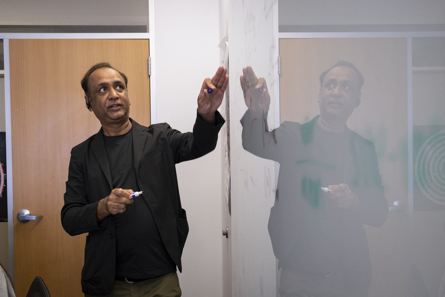 Professor Sudhir Kumar at the white board teaching a small seminar class
