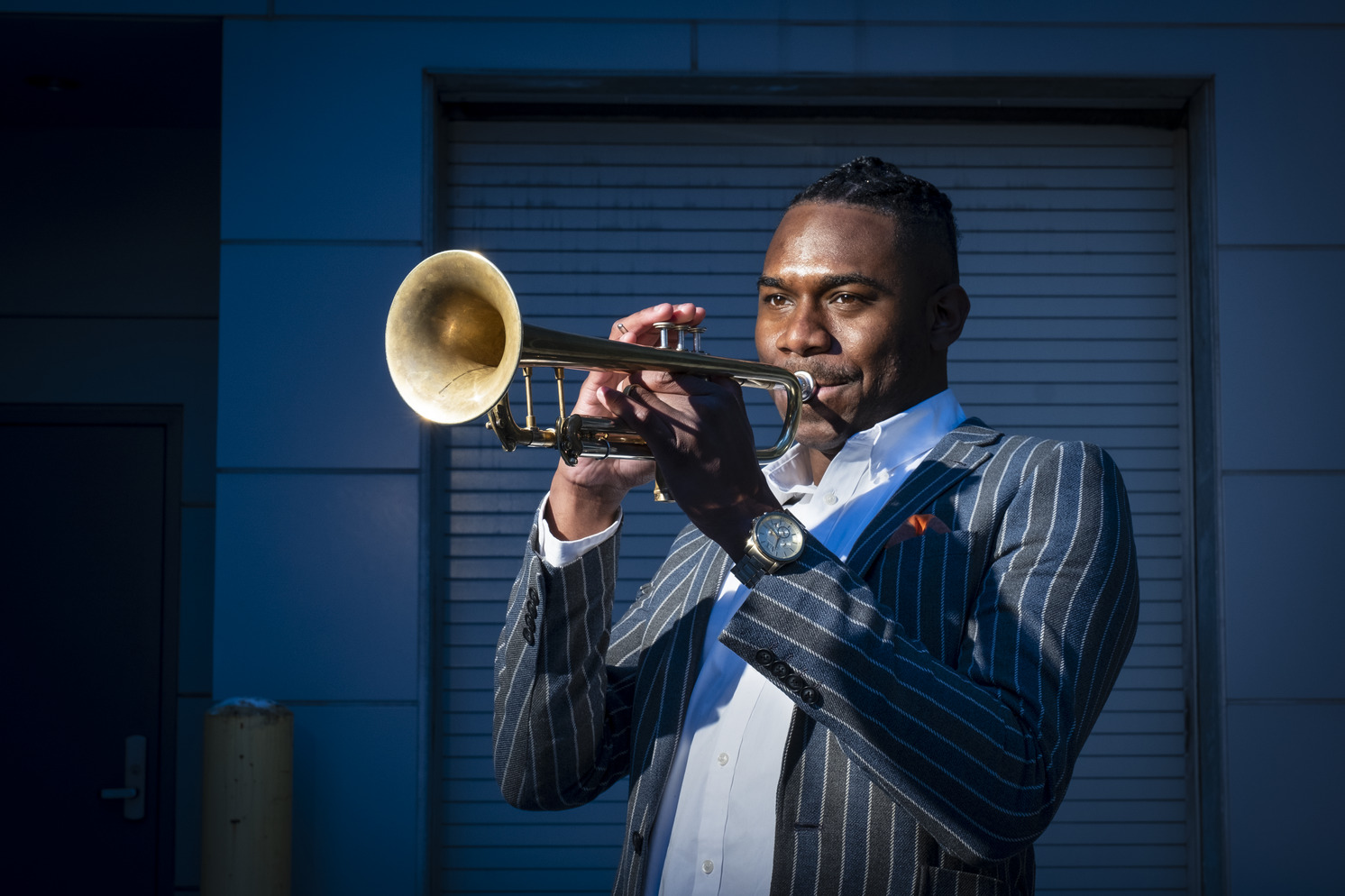 Image of Fareed Simpson-Hankins playing trumpet outside.
