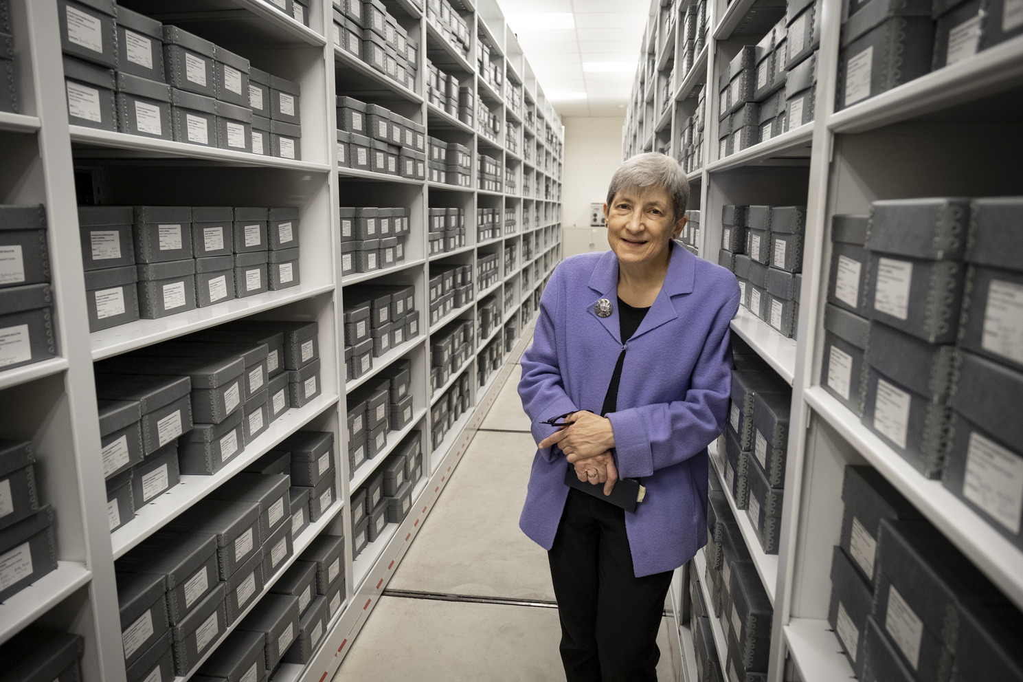 Image of Margery Sly in front of rows of gray boxes.