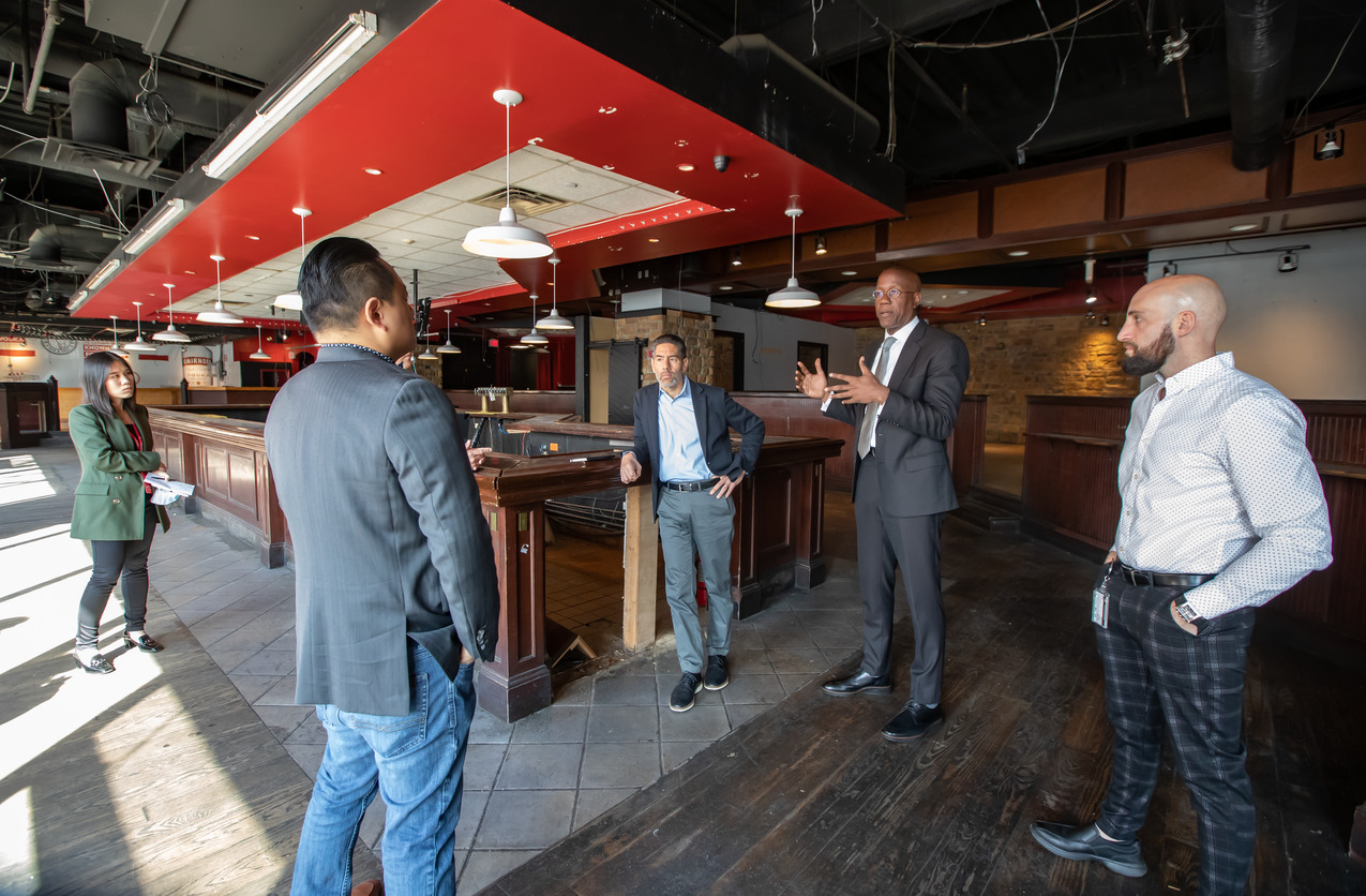 Image of President Jason Wingard and others standing indoors.