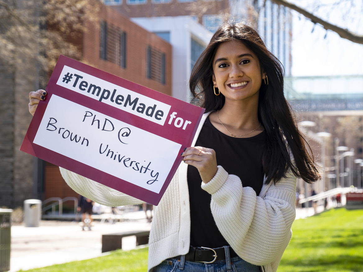 Image of Areebah Rahman outside holding a Temple Made for sign.