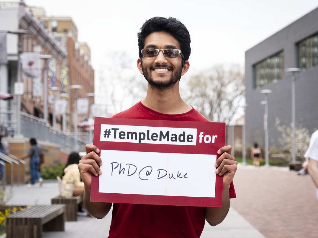 Srikar Katta holding a sign reading Temple Made for PhD@Duke