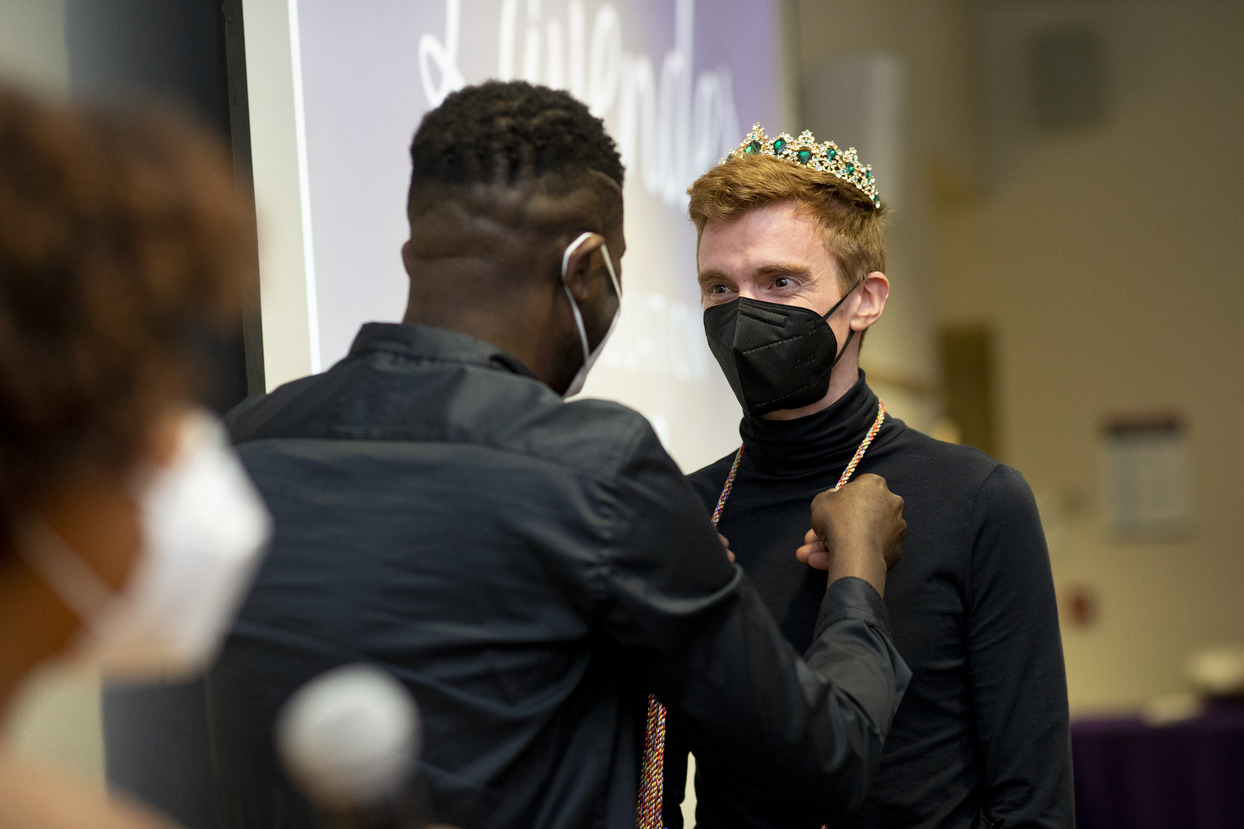 Image of a student in a crown getting rainbow cords.