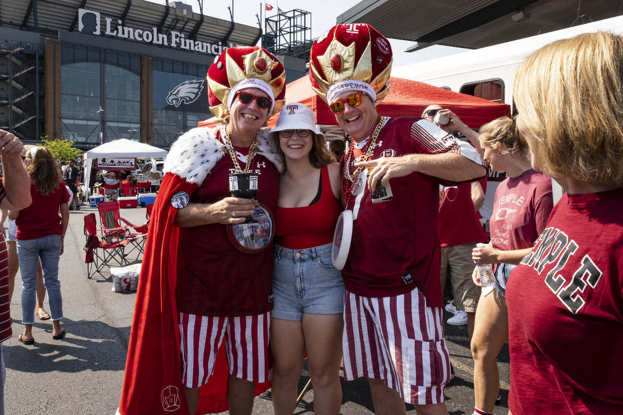 People wearing cherry and white shirts at a Temple University homecoming event.