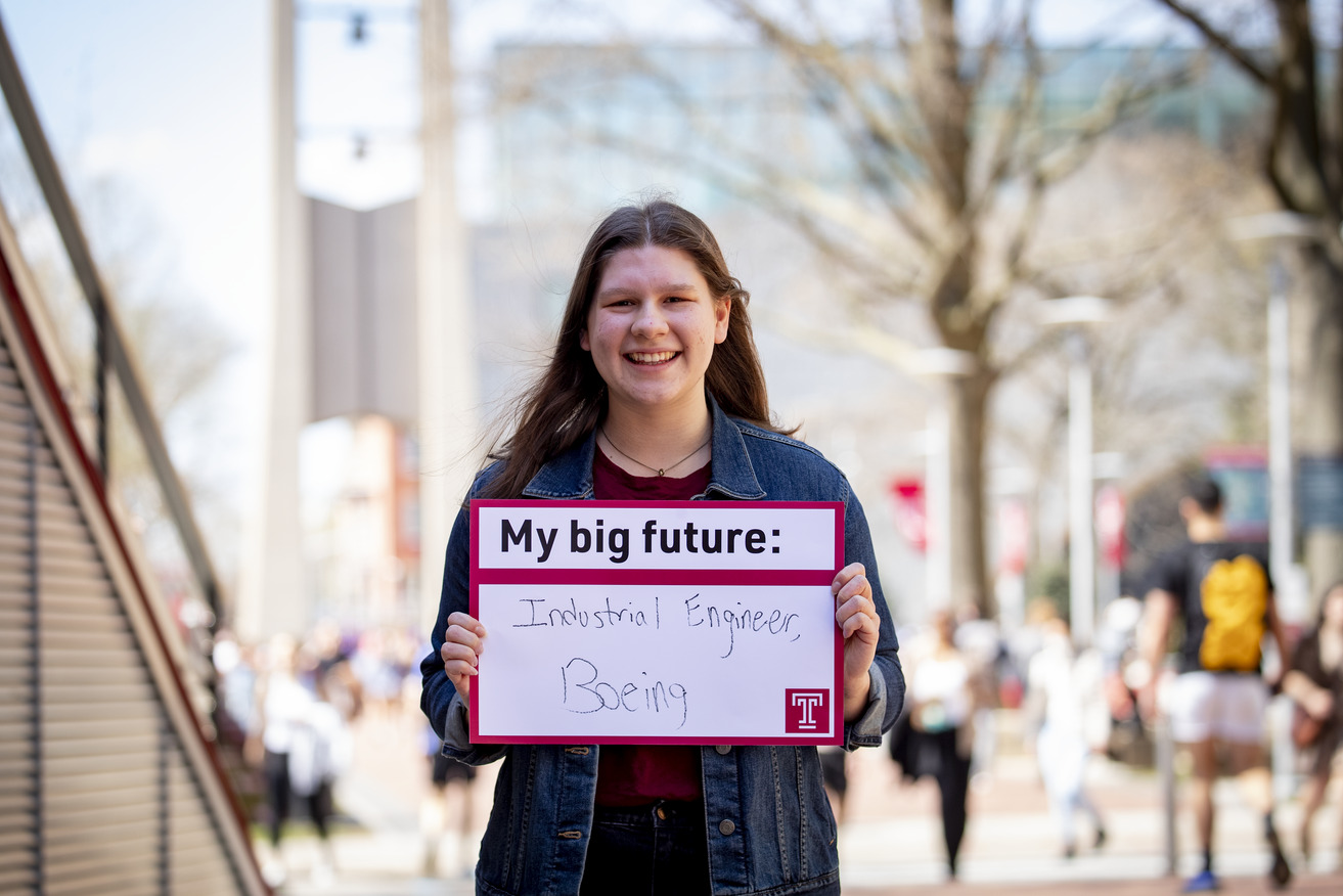 Morgan Schafer outside holding a Big Future sign.