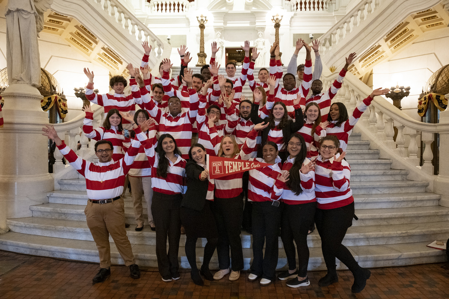 Temple students wearing red and white shirts took a group photo on the steps of the Capitol s main rotunda.