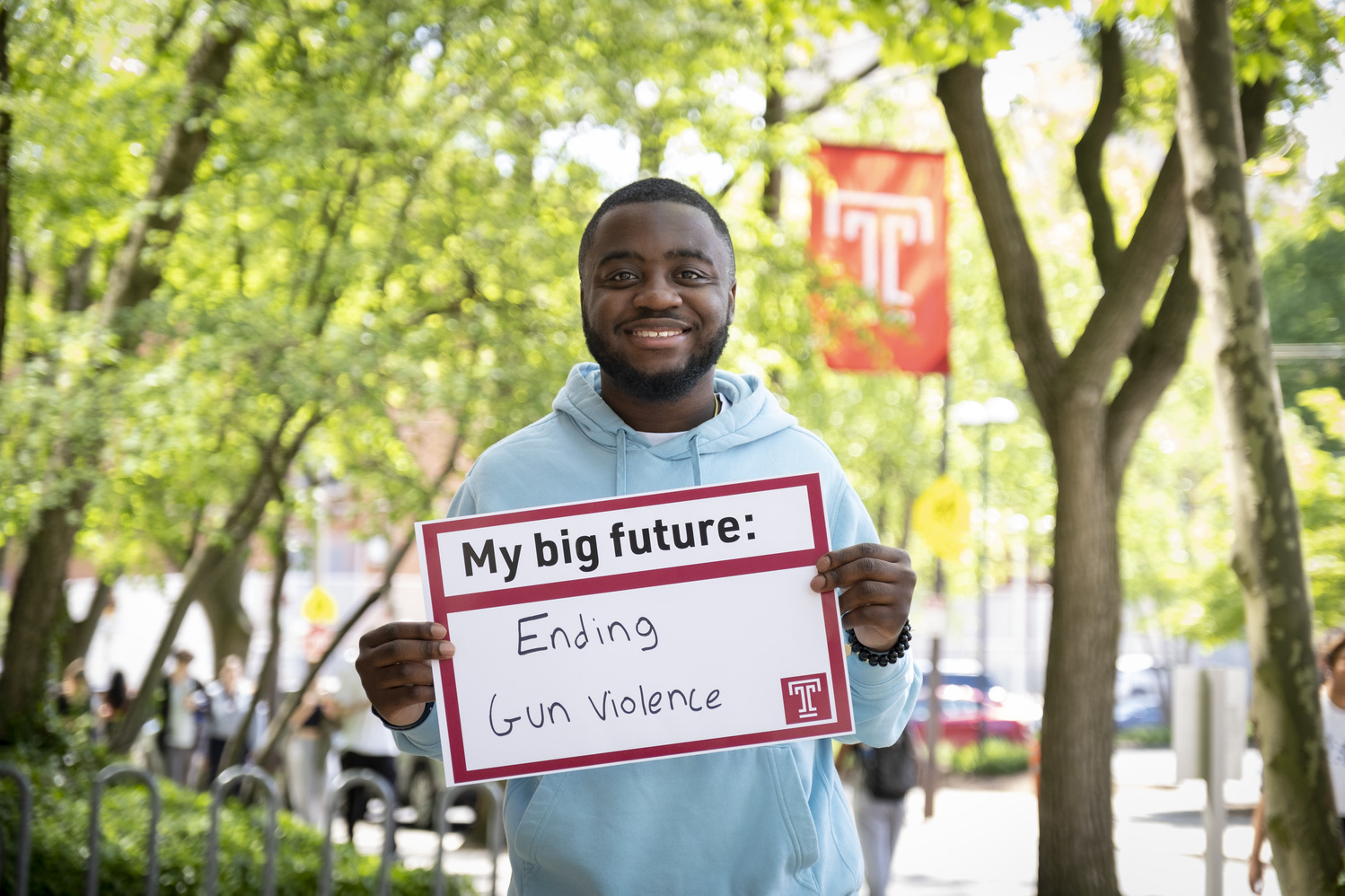 Andrew Ankamah holding a sign that says ending gun violence.