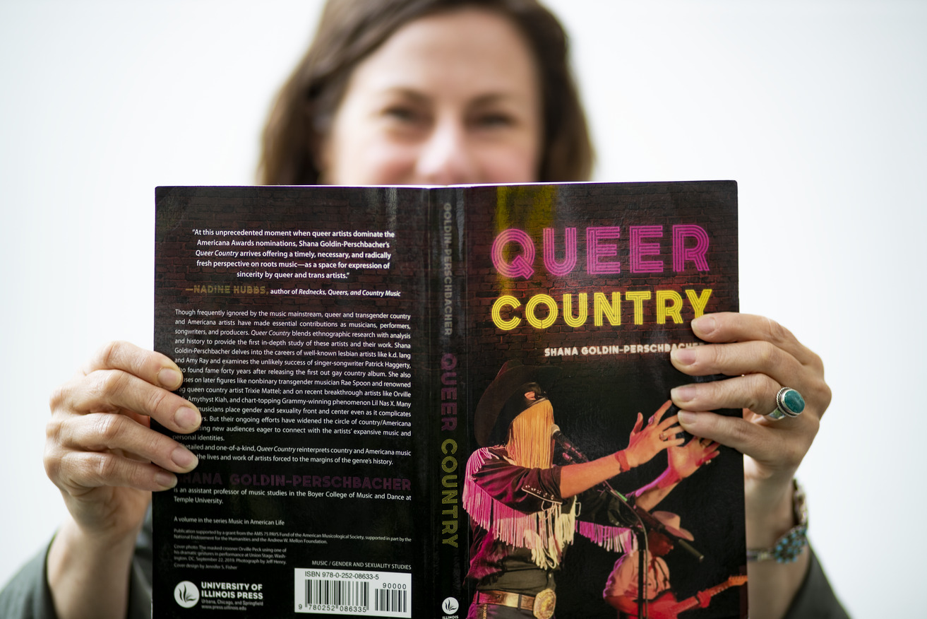 Shana Goldin-Perschbacher holding her book, Queer Country