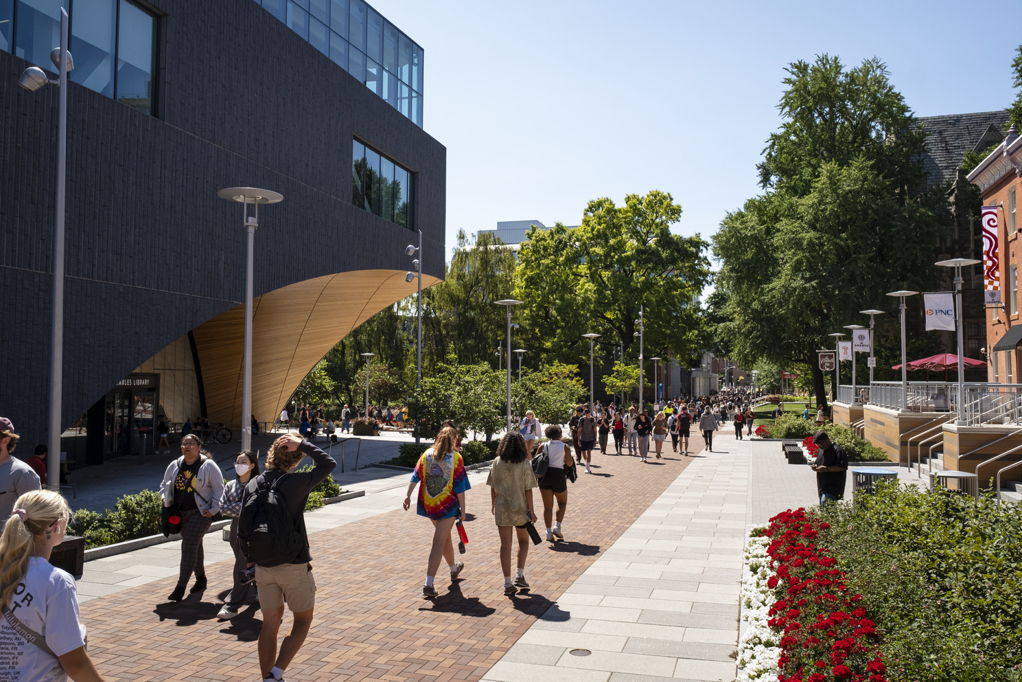 Students walking toward the Bell Tower on a sunny day.