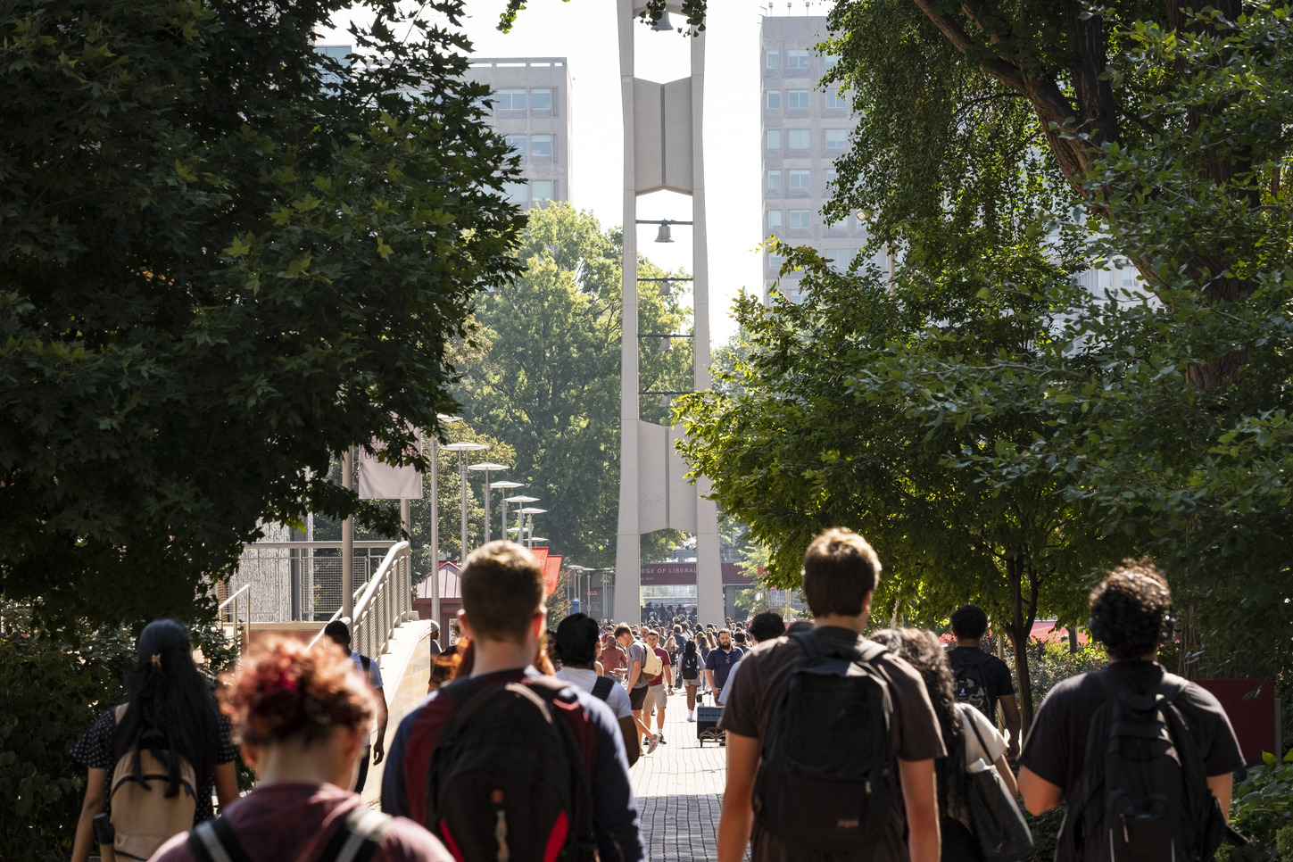Temple students walk to class in front of the campus iconic Bell Tower.