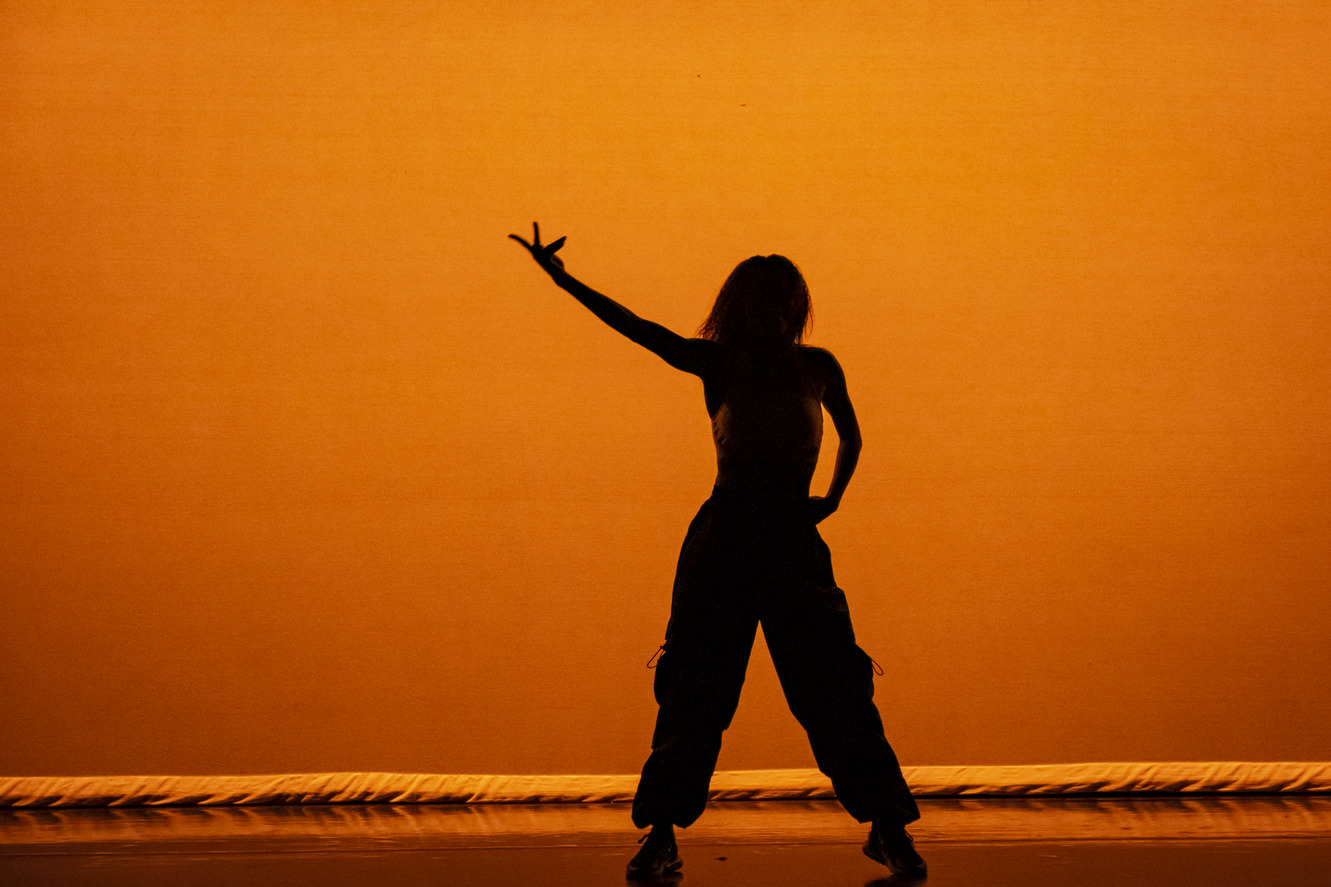 A student's silhouette shown performing at a Temple dance concert