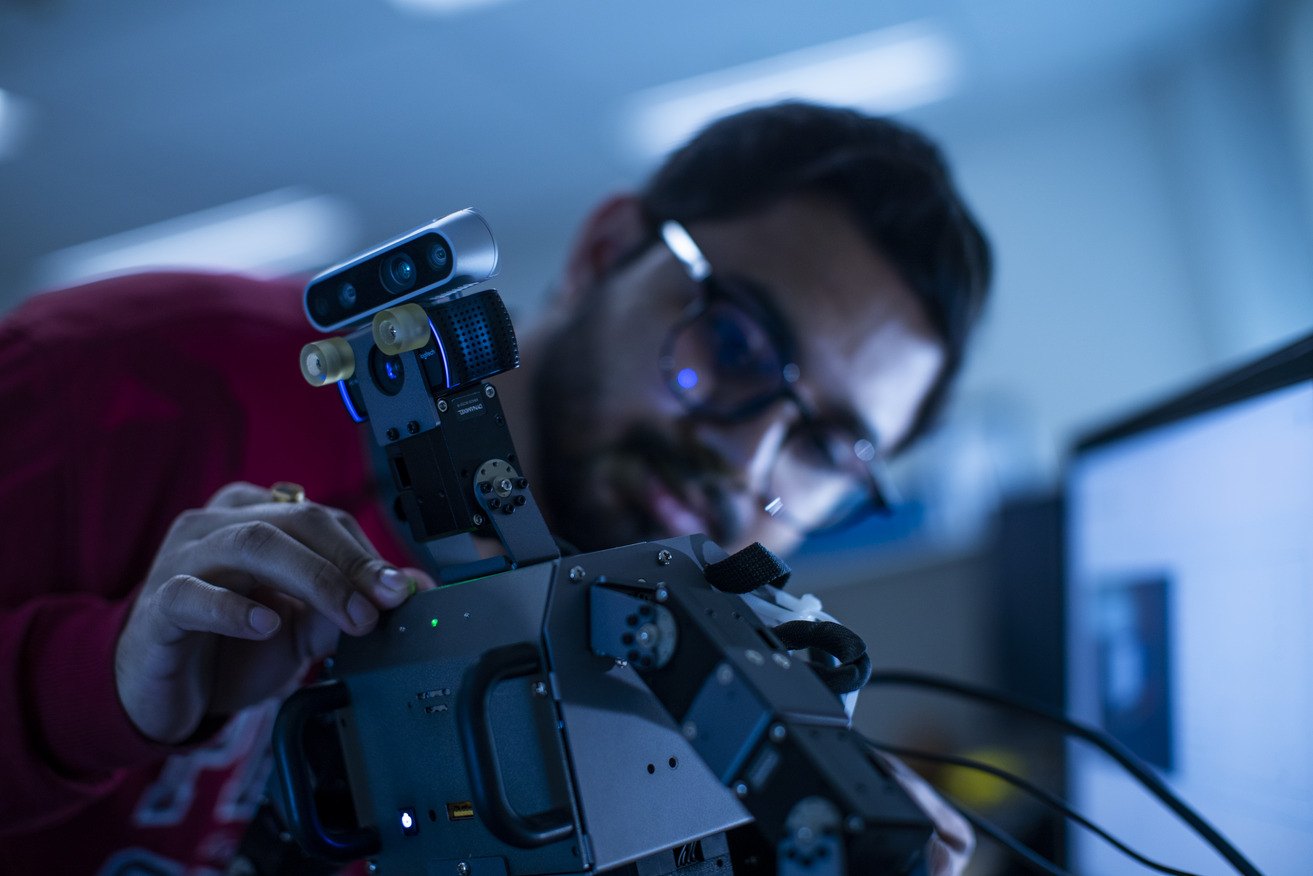 Image of an engineering student with a robot.