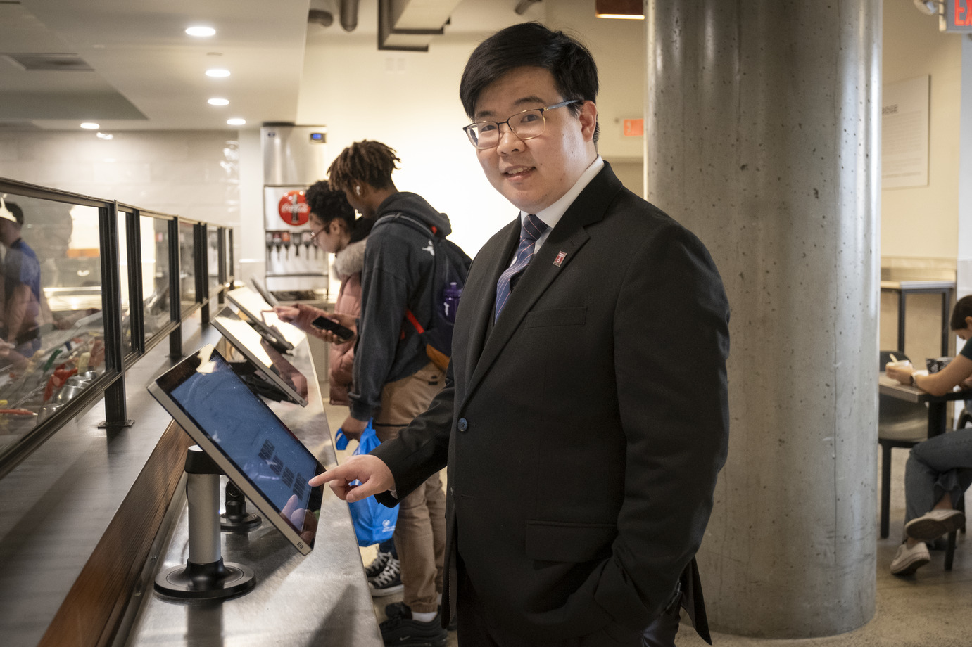 Image of Wangoo Lee at a food ordering kiosk.