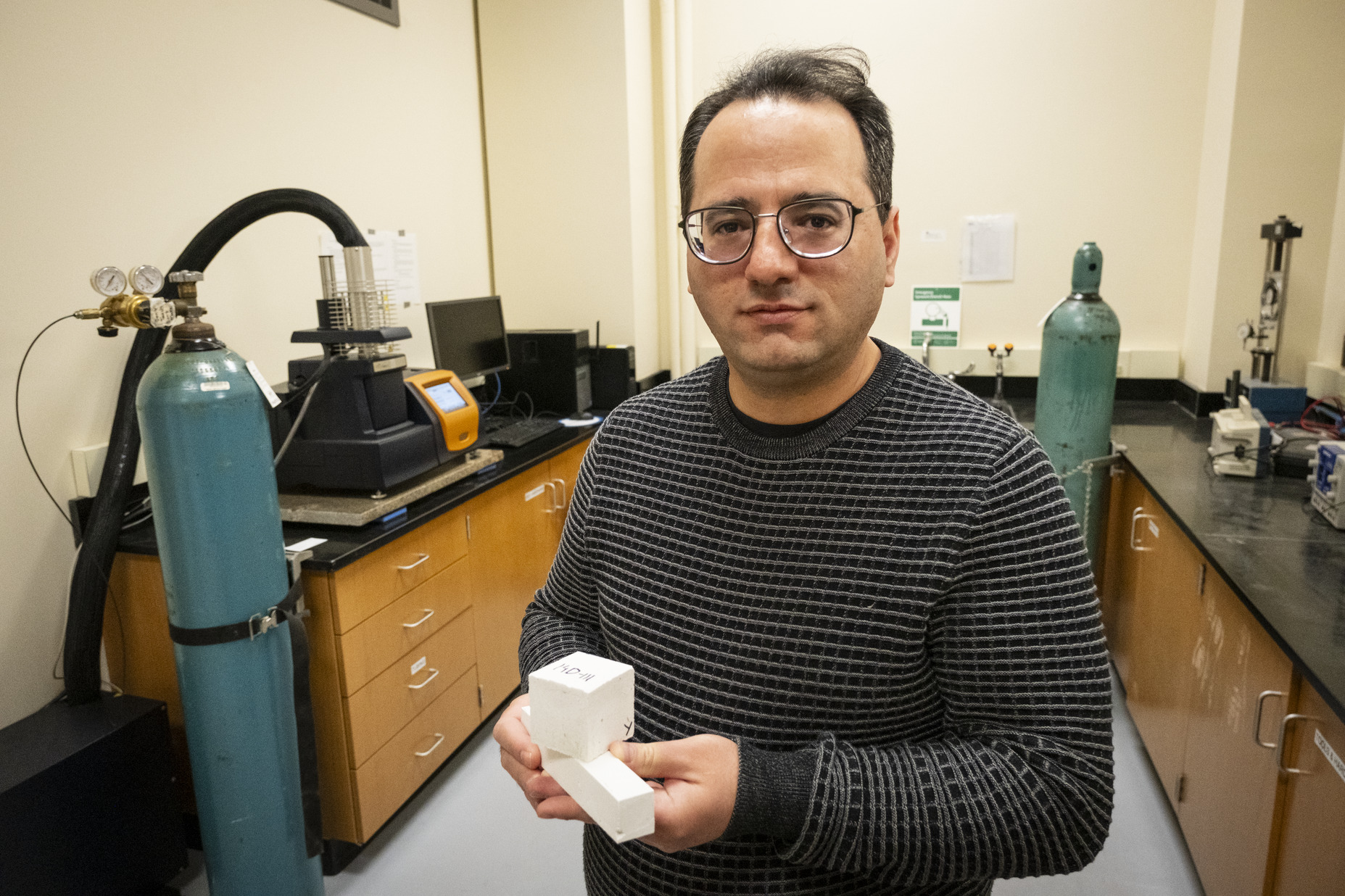 Image of Mehdi Khanzadeh holding a sample of carbonatable concrete.